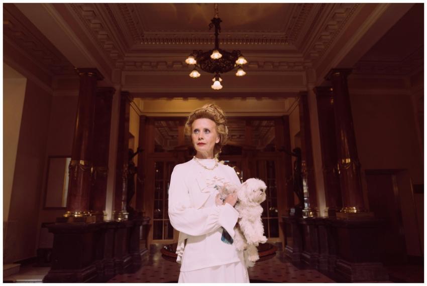 An elegant woman in a classic white dress holding