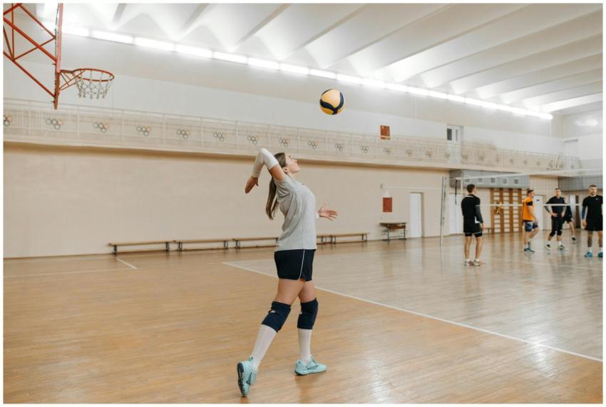 Action shot of a female athlete serving in an indo