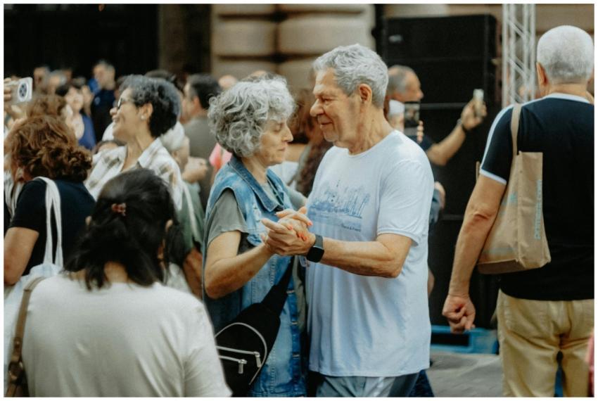 Senior couple dancing joyfully at an outdoor gathe