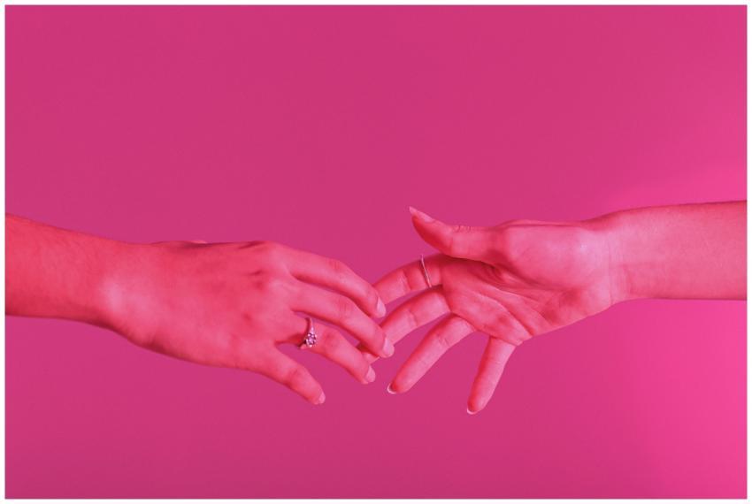 Two people reaching hands towards each other over