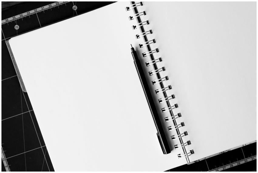 Top view of an open spiral notebook with a black p