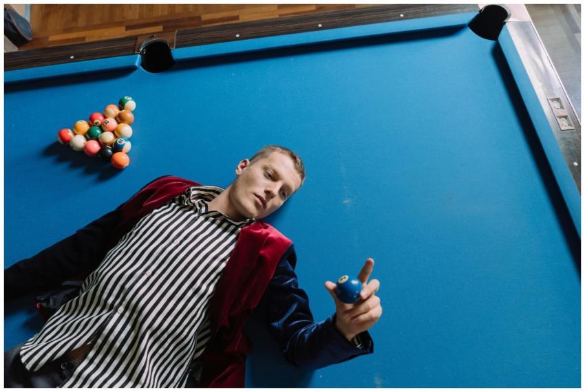 Adult man in a striped shirt lying on a blue billi