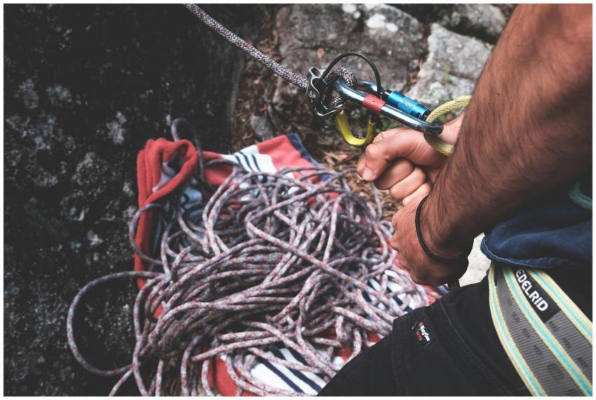 Unrecognizable climber with belay harness with car