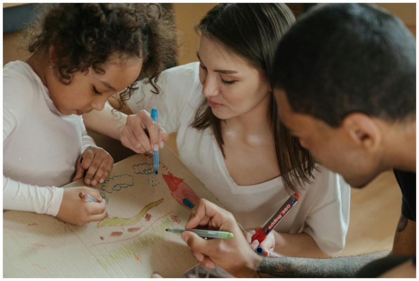 A family drawing together on cardboard, expressing