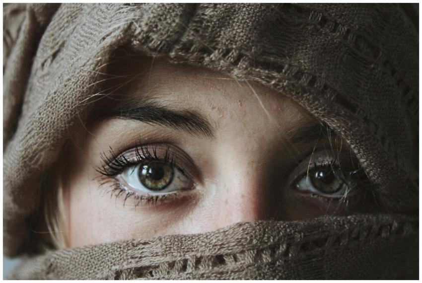 Intense eyes of a woman wrapped in a knitted scarf