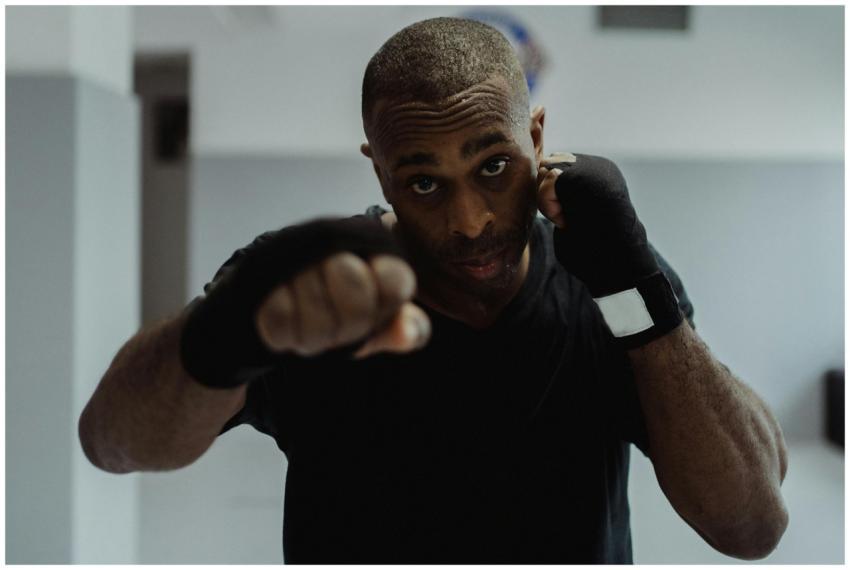 An adult boxer practicing indoors, focused on trai