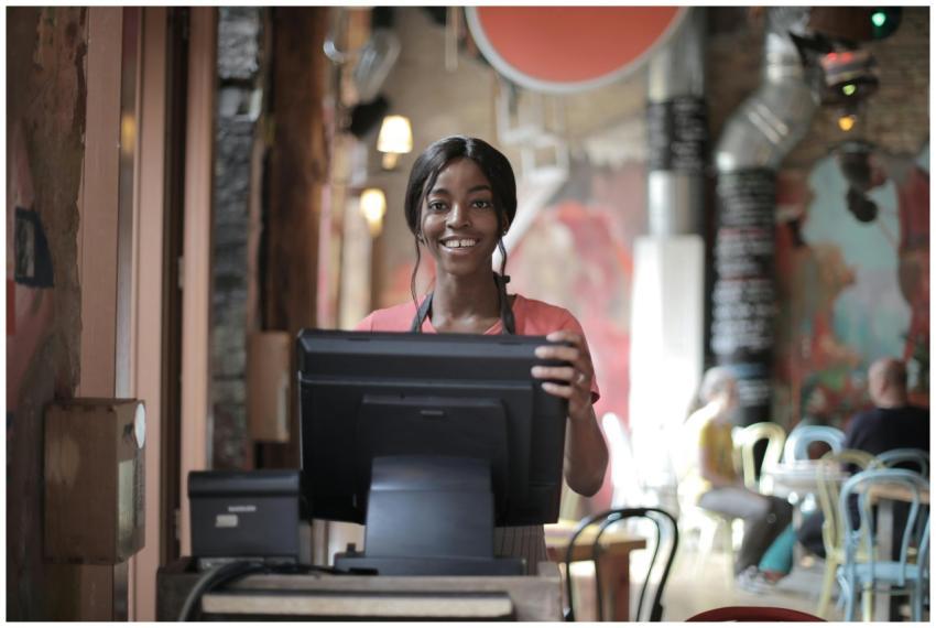 Positive young woman in uniform smiling while stan