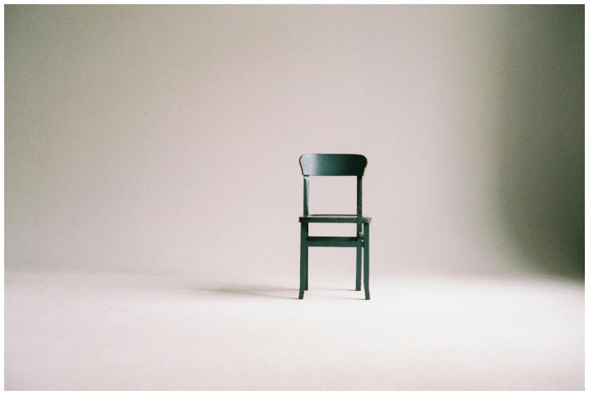 A single black chair in a minimalistic studio sett