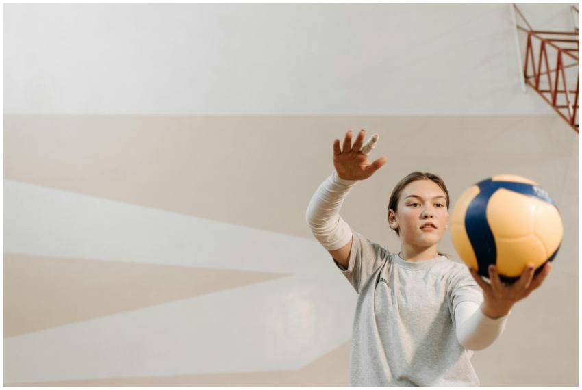 A young female volleyball player practicing indoor