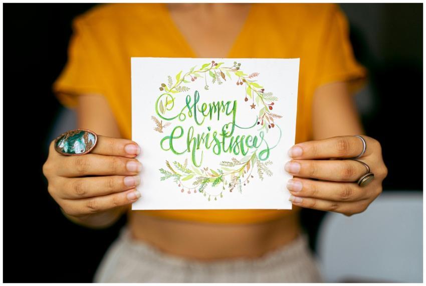 Bright and festive Christmas card held by hands ag