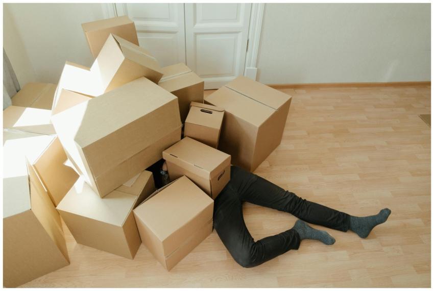 A person overwhelmed by cardboard boxes during a h