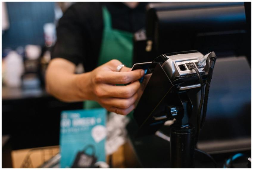 Close-up of a barista processing a payment using a