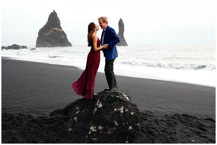 A couple embraces on Reynisfjara Beach, Iceland wi