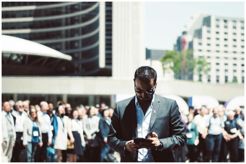 Focused businessman using tablet in a bustling cro
