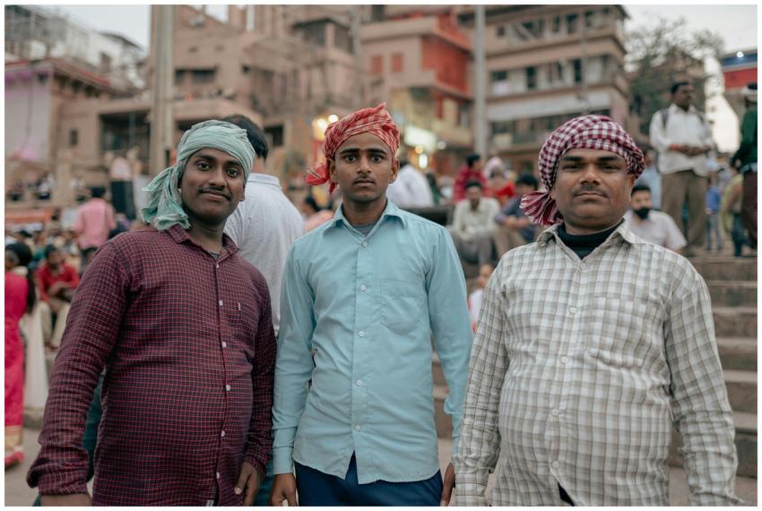 Three men wearing traditional headscarves stand at