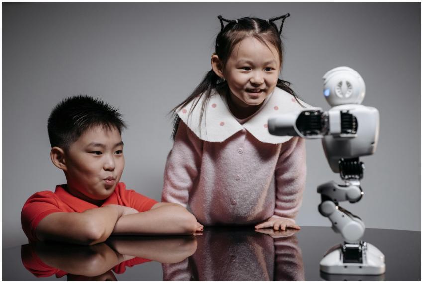Two children interacting with a small robot, showc