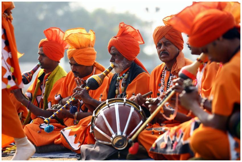 A group of Indian men in vibrant orange traditiona