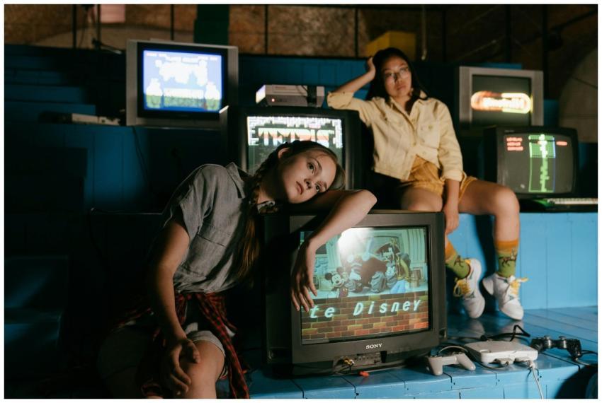 Two women in casual outfits immersed in retro gami