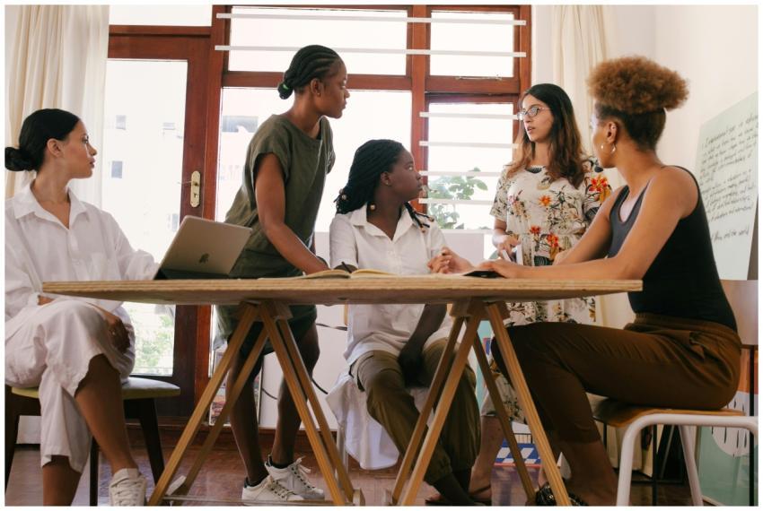 A diverse team of women brainstorming ideas in a m