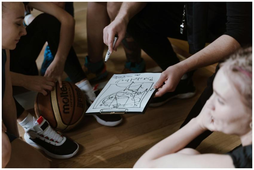 Close-up of a basketball team huddling with the co