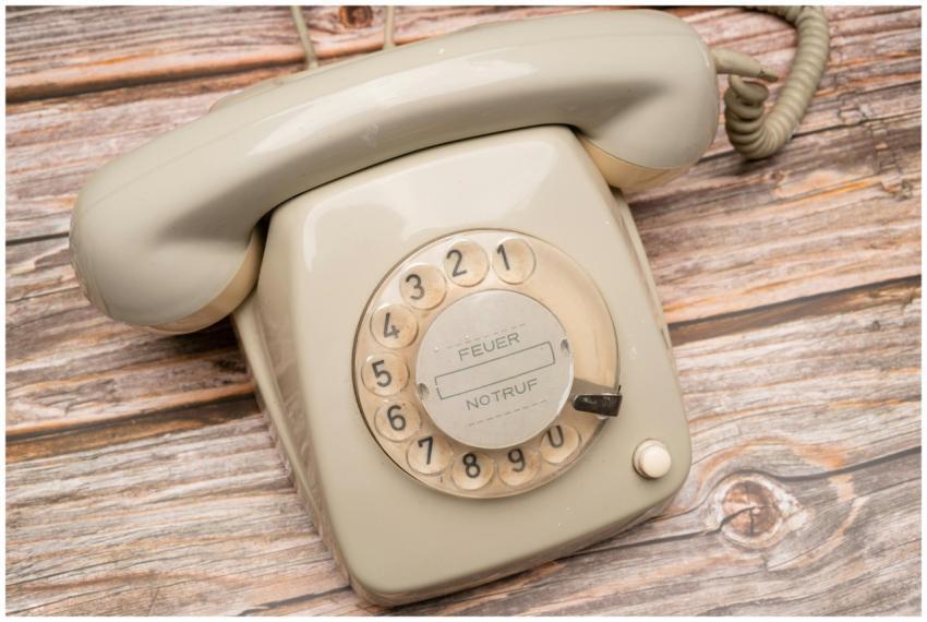Classic beige rotary dial phone on a wooden surfac