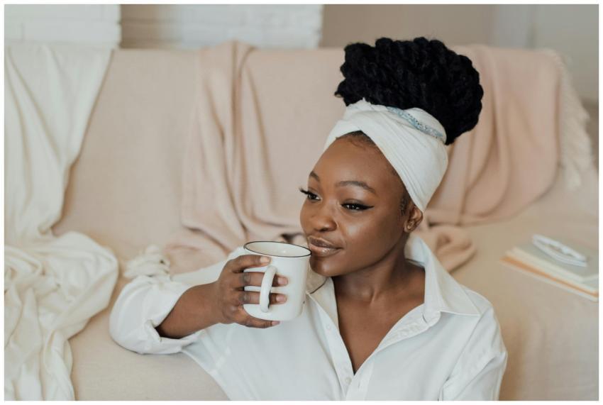 African American woman in white attire drinking co