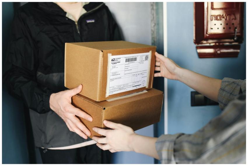 Close-up of hands exchanging cardboard boxes indoo