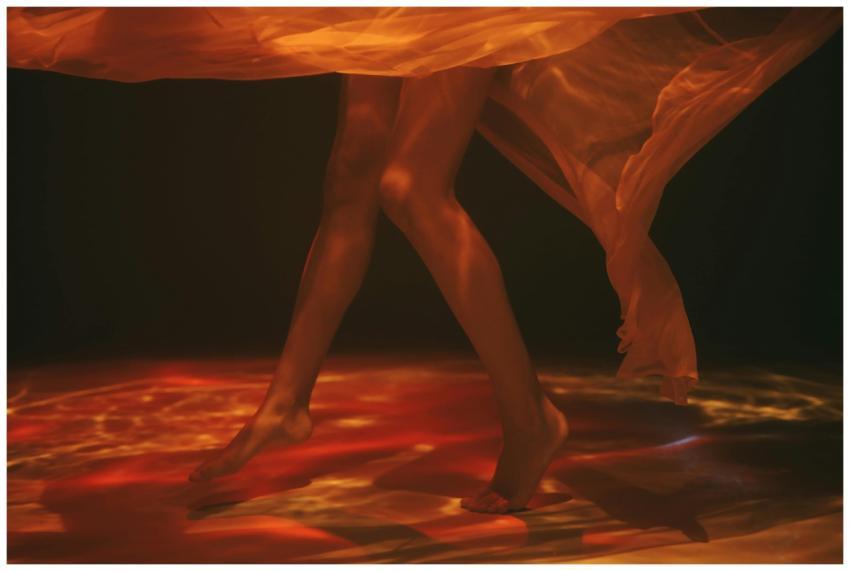 Creative underwater photo of legs and sheer fabric