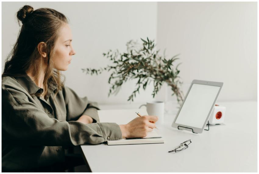 Freelancer writing notes in a minimalist home offi