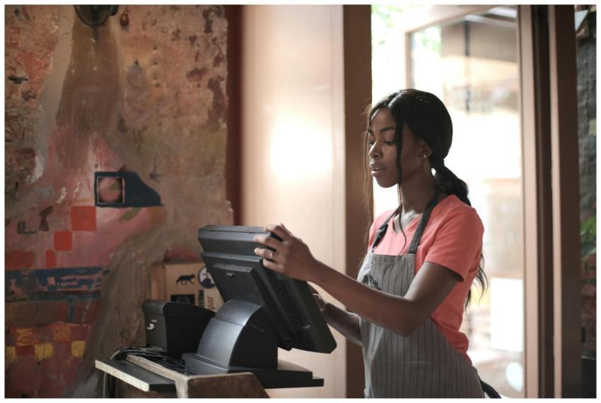 A diligent cashier processes sales in a charming s