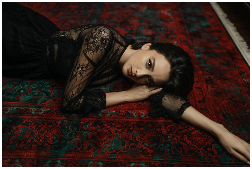 A woman in a lace dress poses elegantly on a vibra