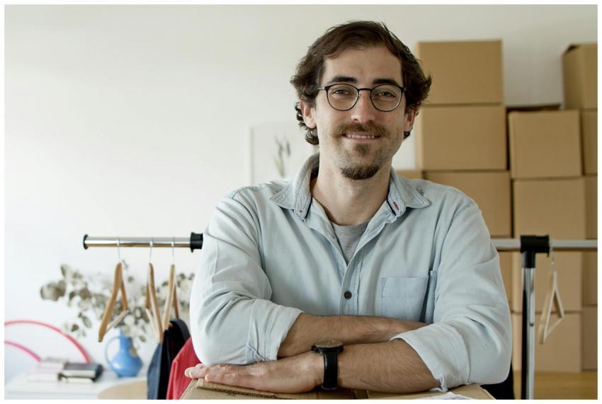 Young businessman with glasses smiling in a startu