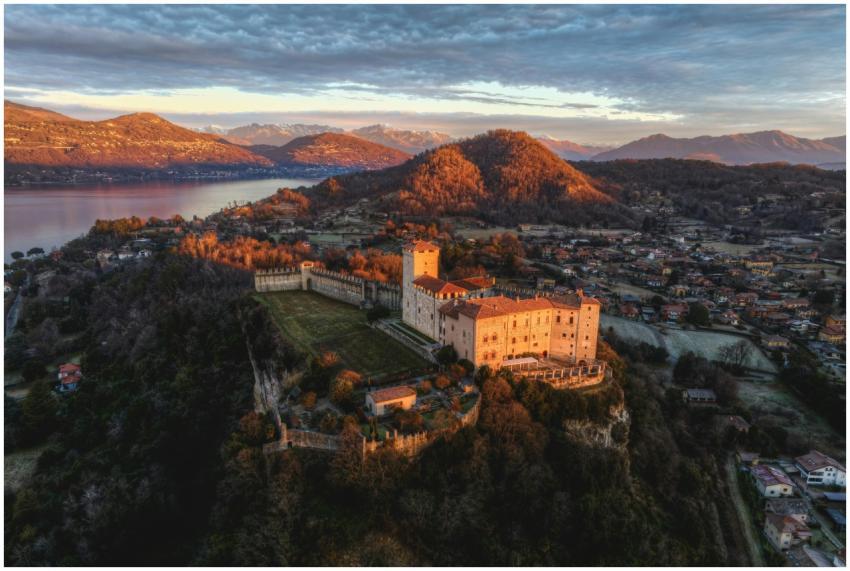 Aerial view of a historic castle overlooking a lak