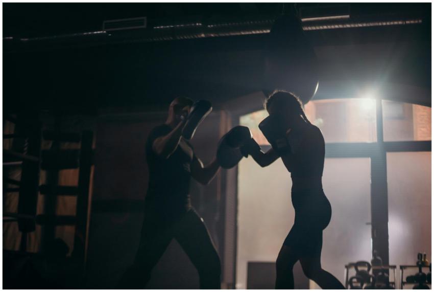Silhouetted boxers sparring during an intense trai