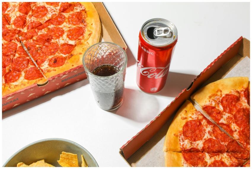Top view of pepperoni pizza, soda, and chips for a