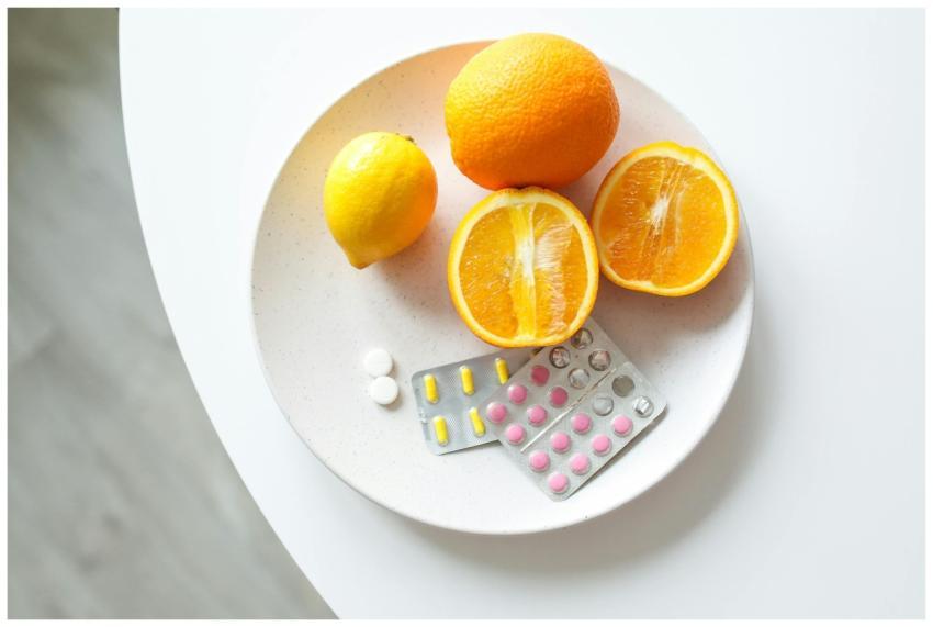 A plate of fresh citrus fruits and blister packs o
