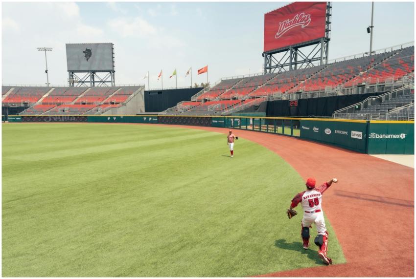 Two baseball players on field with empty bleachers