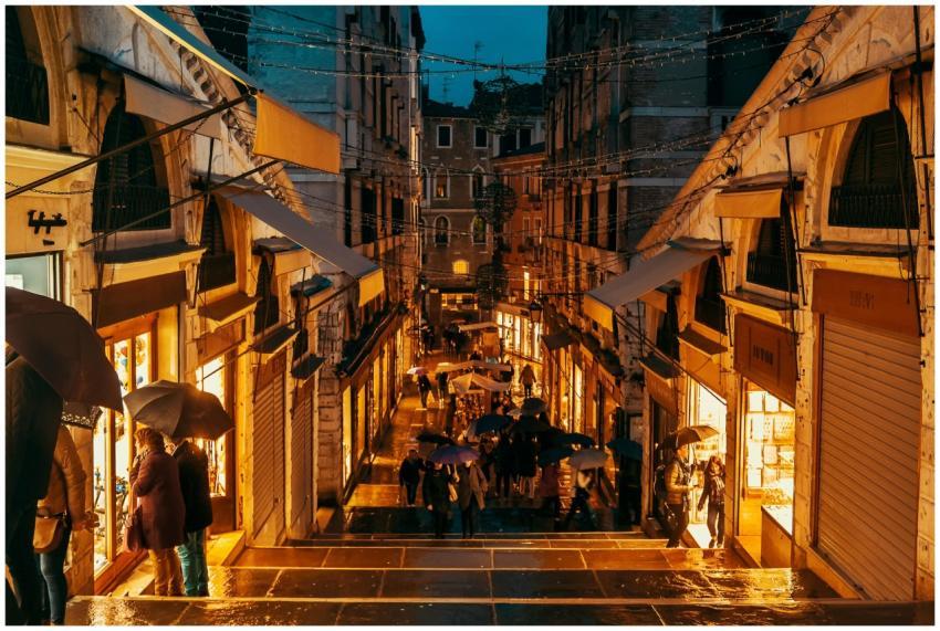 A vibrant scene of people walking under umbrellas
