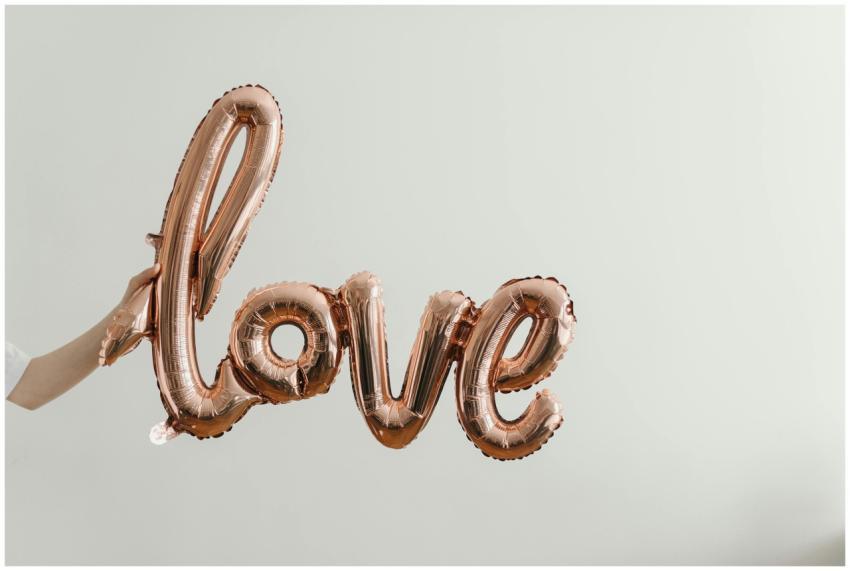 Elegant rose gold balloon spelling 'love' on a sof