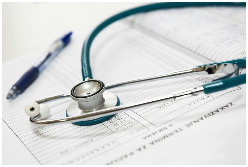 A stethoscope and pen resting on a medical report