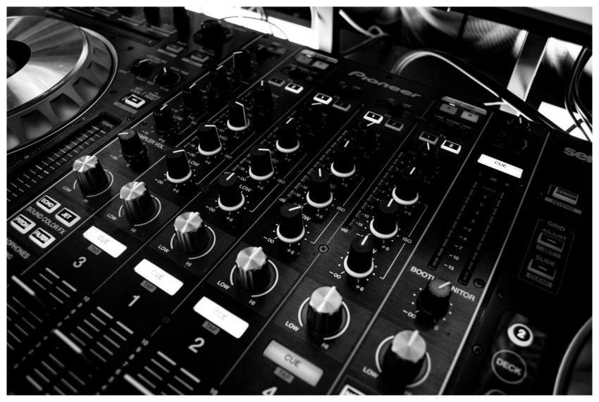 Black and white close-up of a DJ's audio mixing co