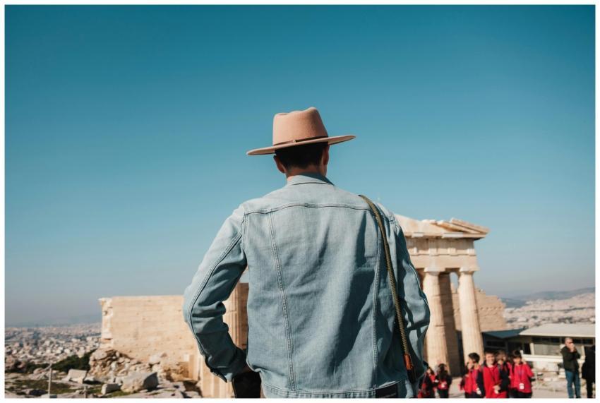 Back view of a man in a jean shirt and hat visitin