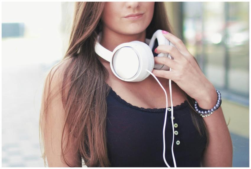 A young woman with long hair, wearing headphones,