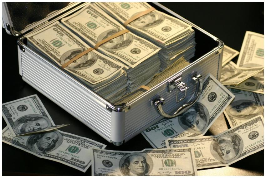 A metallic briefcase full of US dollar bills, symb