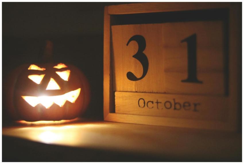 A glowing jack-o-lantern next to a calendar showin
