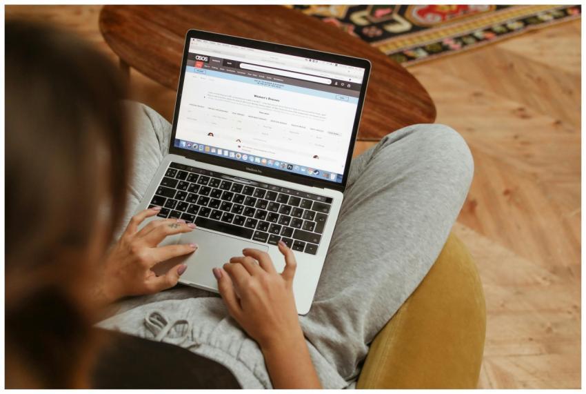 A woman relaxes with her laptop browsing online sh