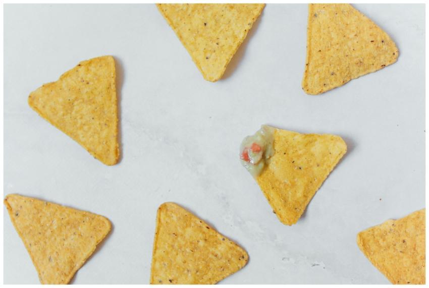 Flat lay of crunchy tortilla chips with guacamole