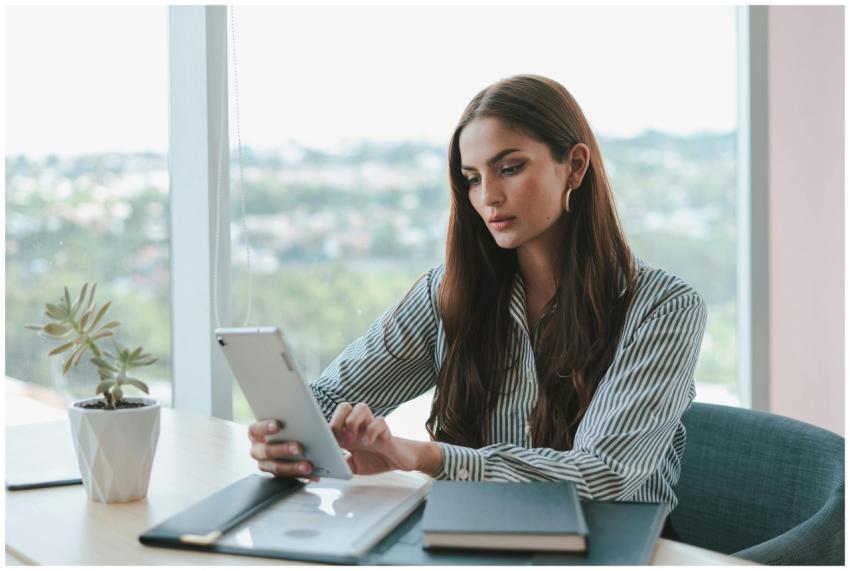 Confident businesswoman using a tablet while sitti