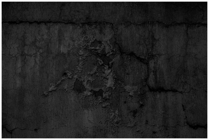 A textured close-up of a dark grunge concrete wall