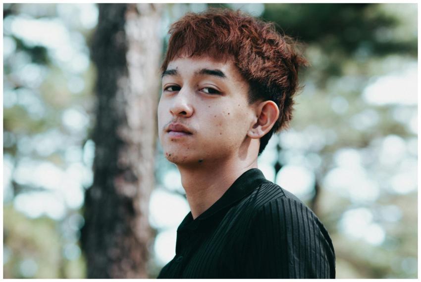 Close-up outdoor portrait of a young man with blur